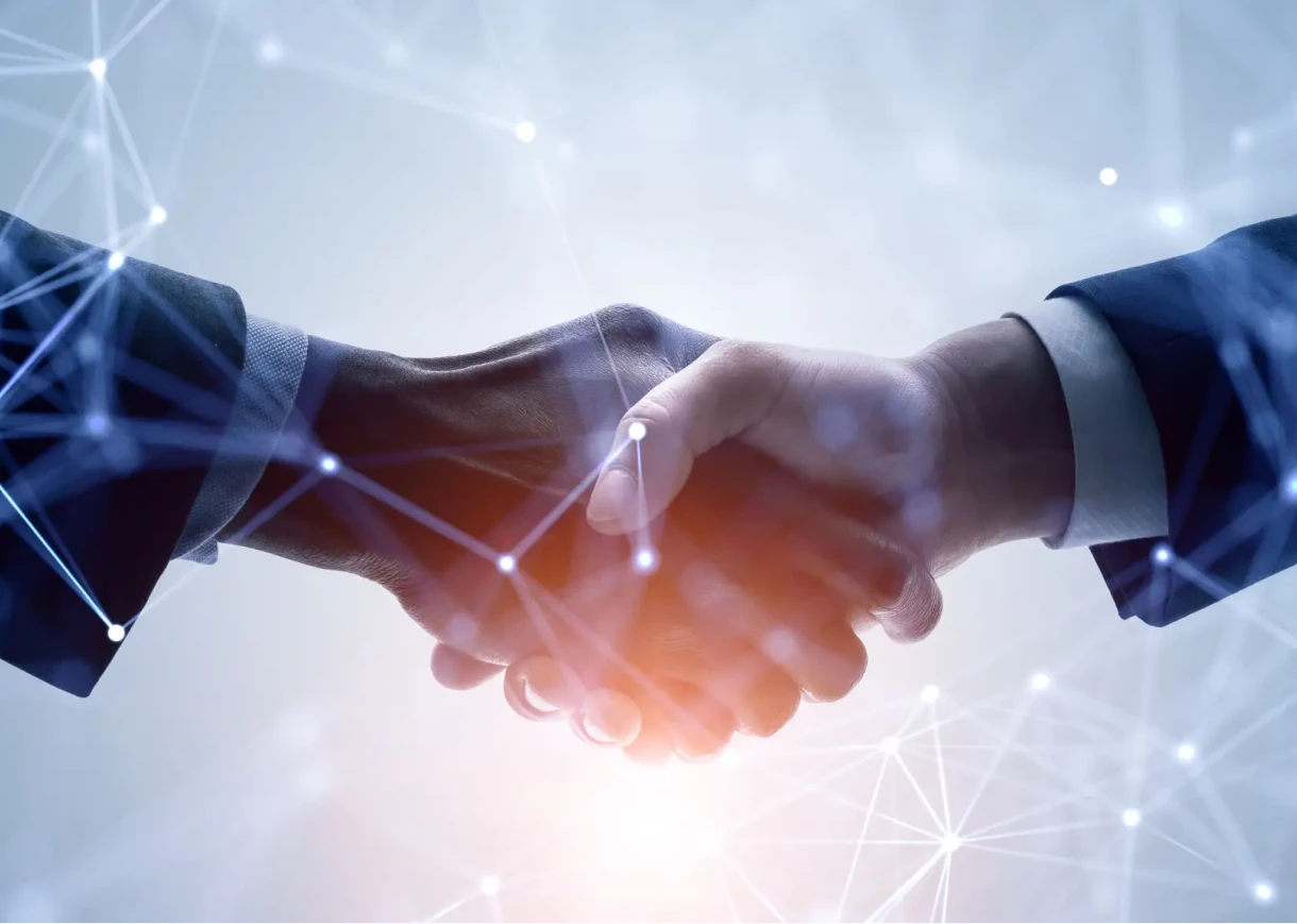 Two hands shaking with technology background